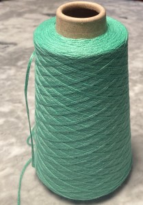 Cone of green cotton yarn