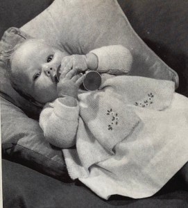 Baby in a knitted cardigan, pattern photo from Stitchcraft magazine, June 1963