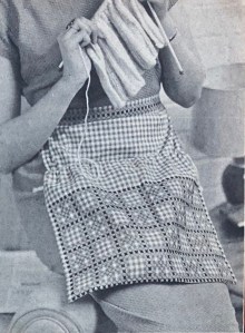 Photo of a woman wearing a knitting apron and knitting, Stitchcraft magazine, October 1963